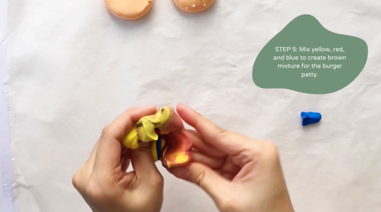 Step 5 of the DIY clay burger tutorial: Mix yellow, red, and blue to create a brown mixture for the burger patty.