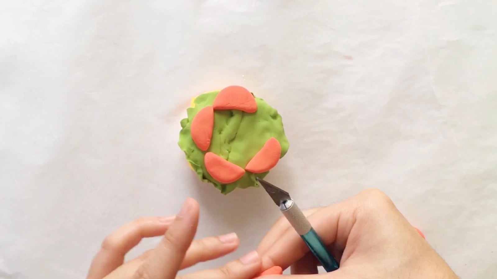 Step 9 of the DIY clay burger tutorial: Get your red clay for the tomatoes. Cut them into pieces and put them on top of the lettuce.