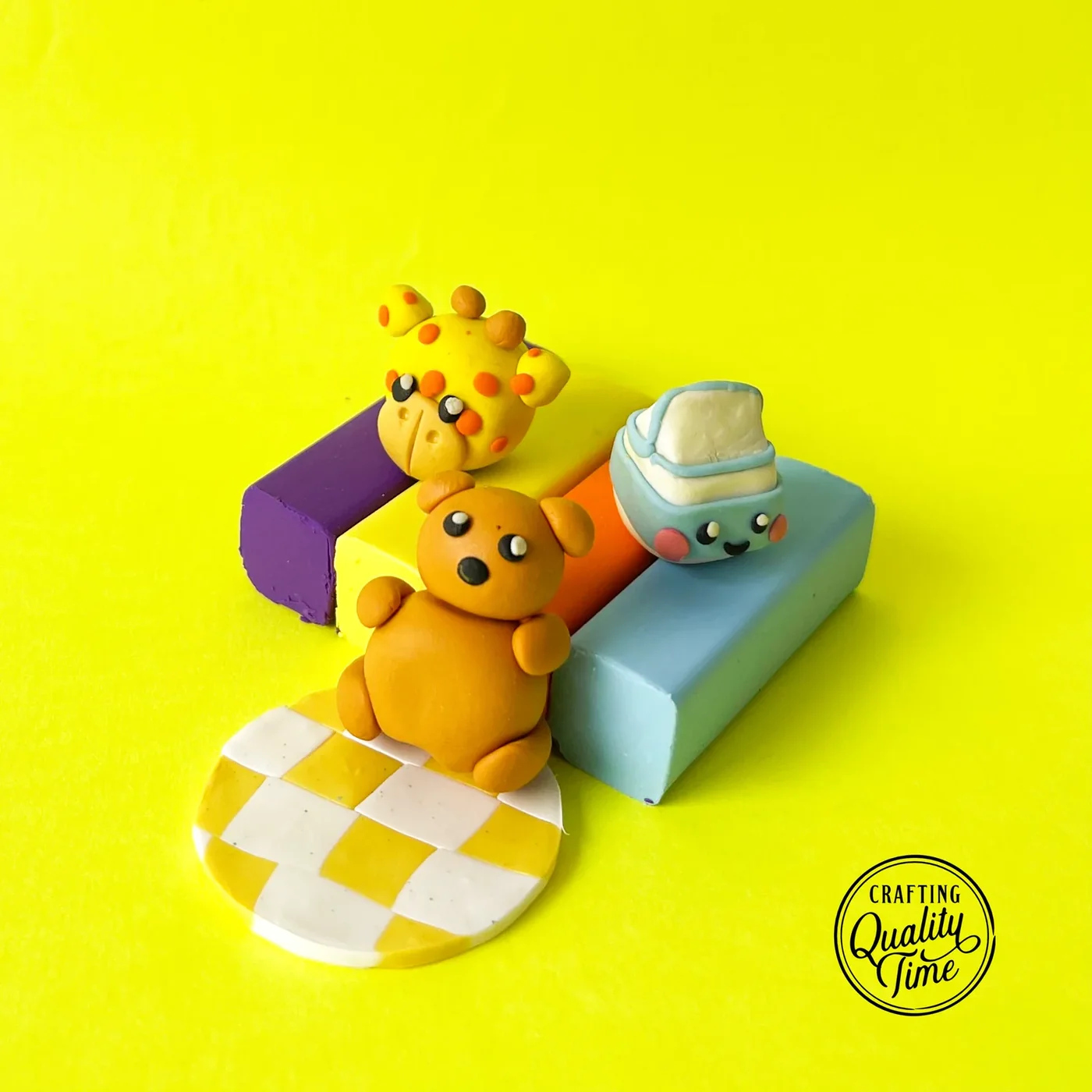 Finished clay animal erasers on eraser blocks: a spotted giraffe, a brown bear, and a smiling milk carton