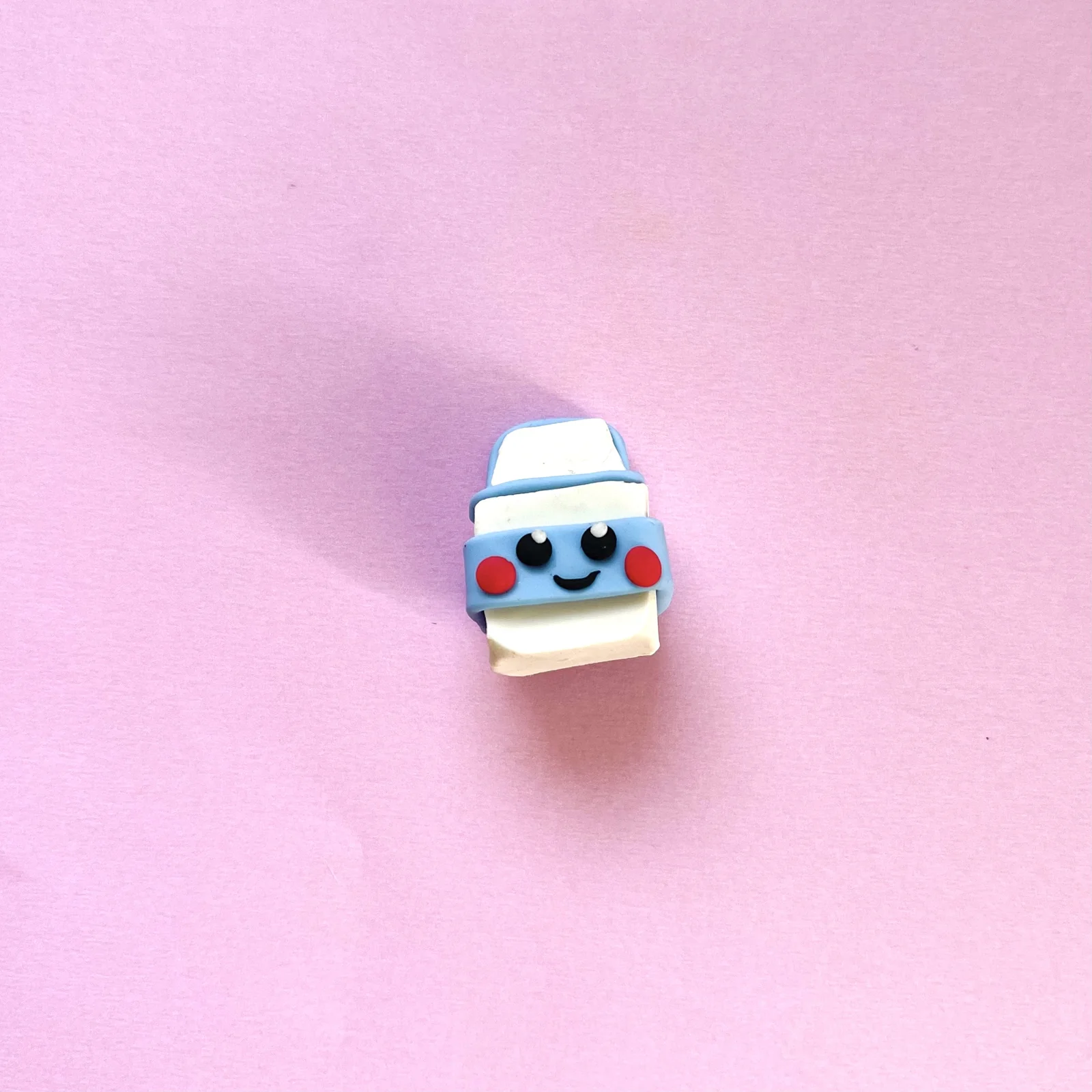 Step 4 of the mini clay food erasers tutorial: add a smiling face with black, white and pink clay