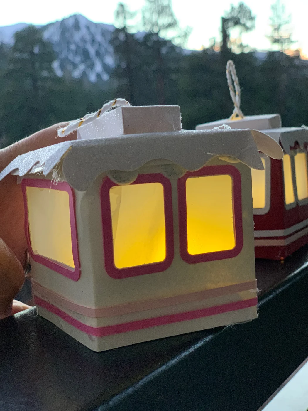 Close-up of a paper gondola with warm light glowing through its frosted paper windows